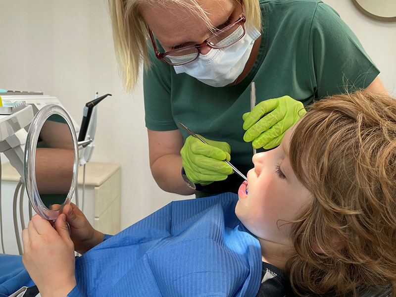 Prophylaxe-Behandlung eines Kindes bei einer Zahnärztin